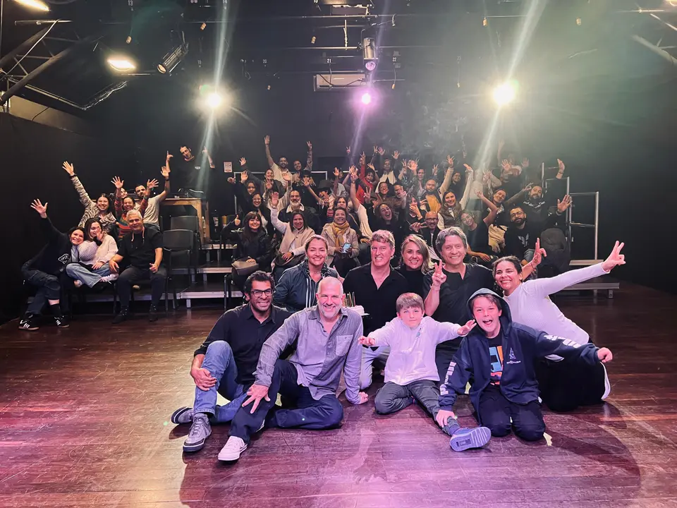 Foto grupal de la comunidad en el teatro durante el aniversario